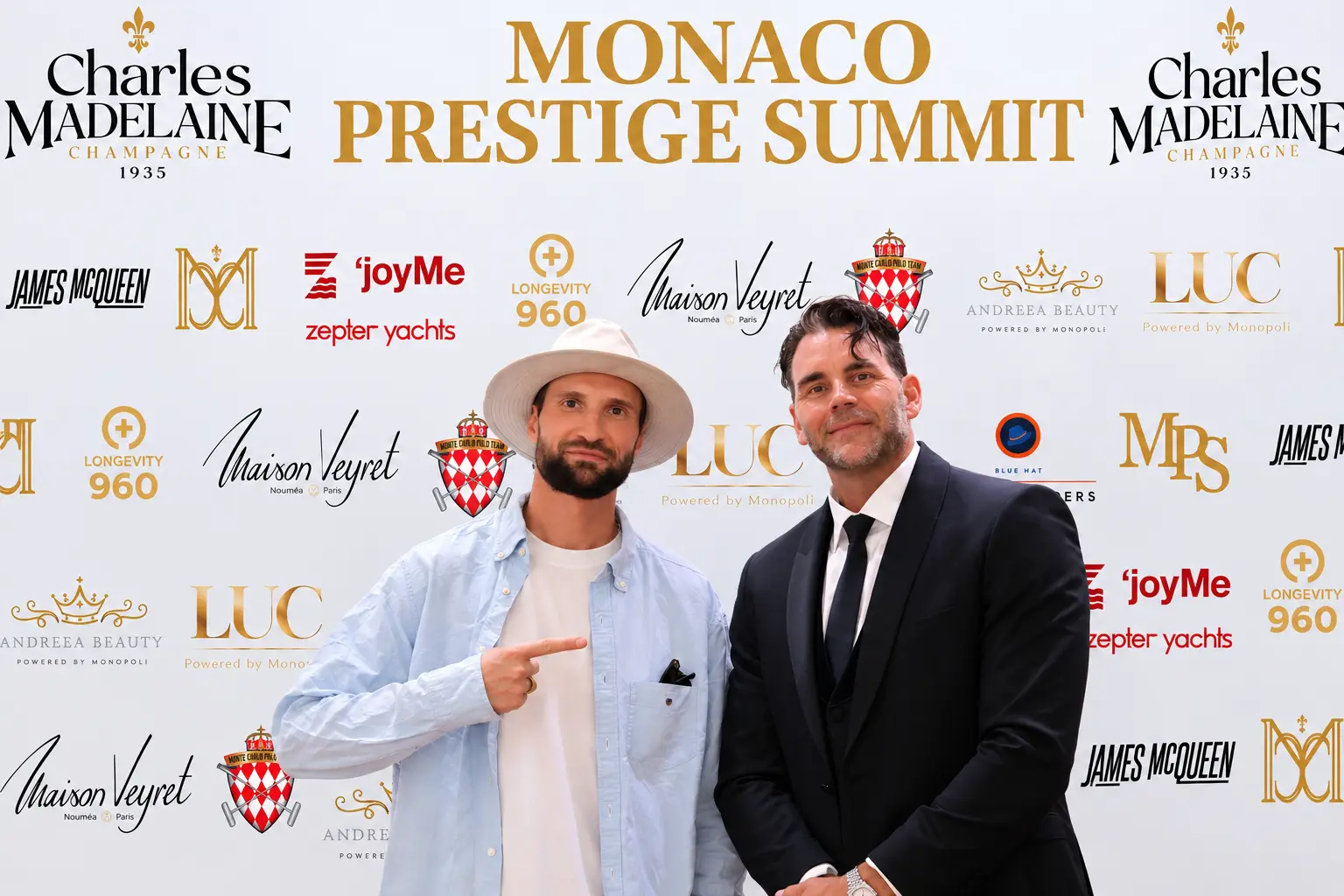 Guests in a straw hat and tuxedo at the Monaco Prestige Summit media wall