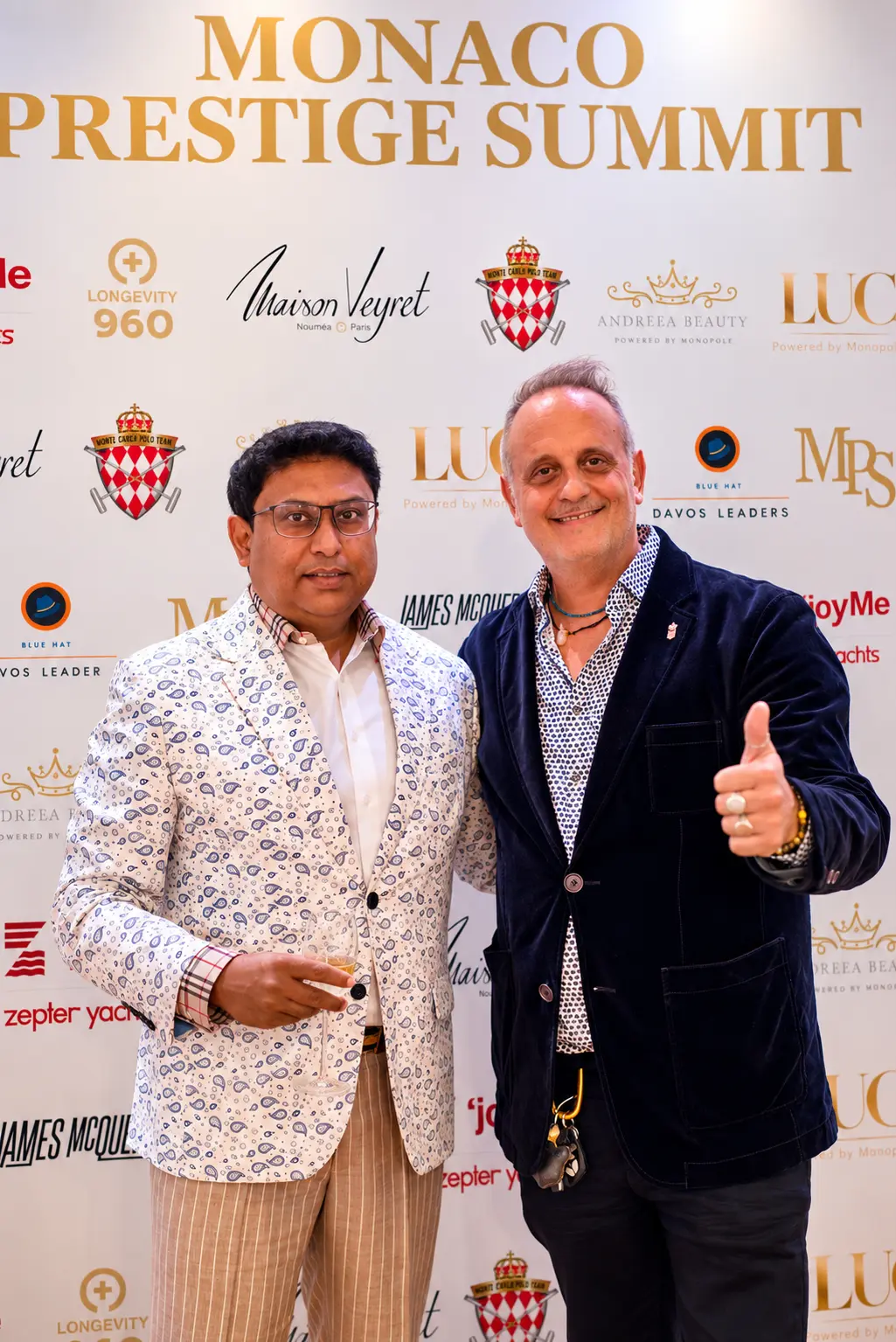 Guests in a paisley jacket and velvet blazer at the Monaco Prestige Summit media wall