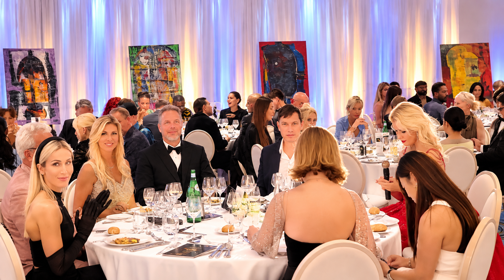 Gala dinner guests seated beneath colourful artwork at the Summit